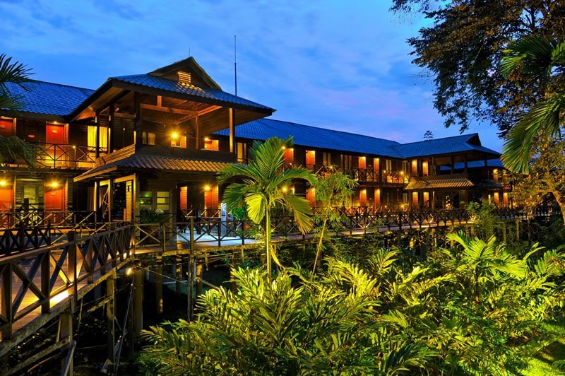 Raised wooden walkways and lit guest wings at Mulu Marriott Resort and Spa, Sarawak